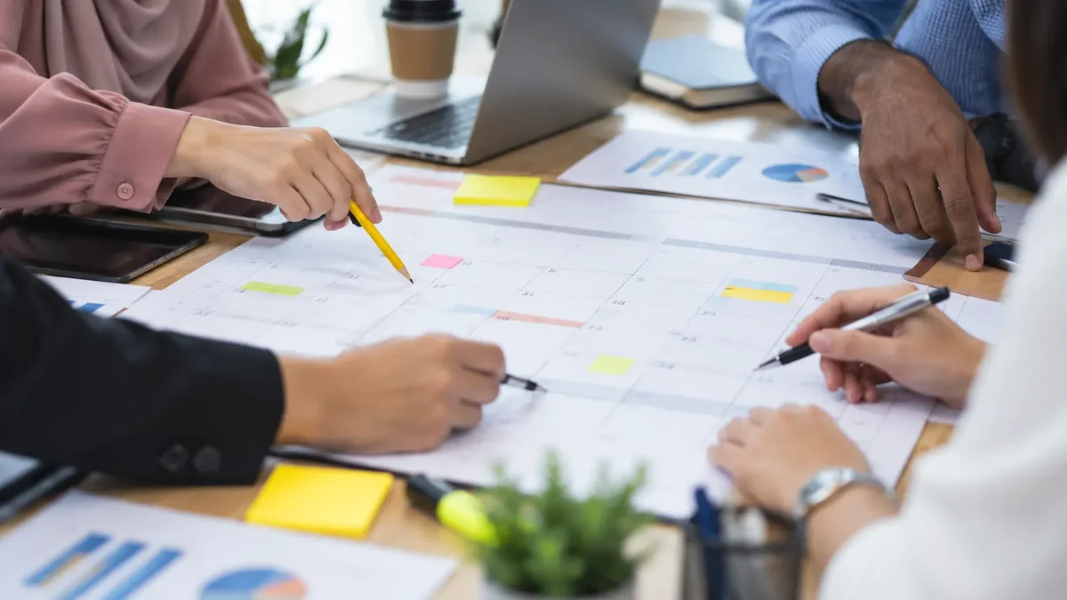 Colleagues planning a workplace programme around a calendar